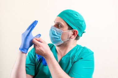 Maskeli ve şapkalı bir doktor eldivenle oynar. Yüksek kalite fotoğraf