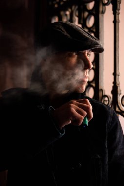 Paltolu ve şapkalı bir adam şehirde dolaşıyor..