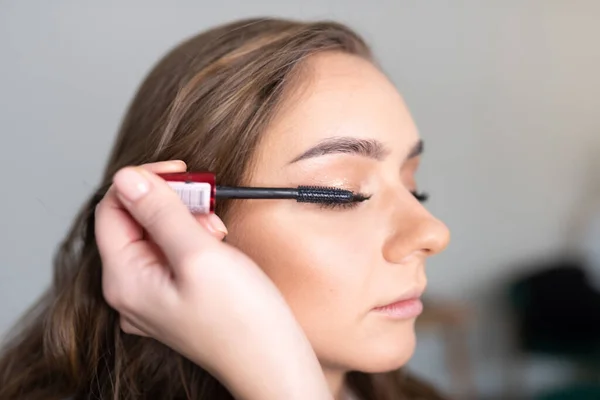 Maquiagem artista aplica rímel para as pestanas meninas, close-up — Fotografia de Stock