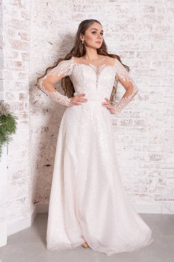 Tuğla duvara dayalı beyaz elbiseli gelin. Yüksek kalite fotoğraf