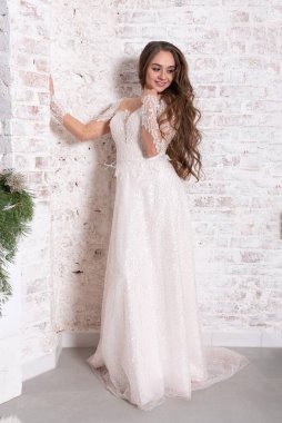 Gelin, beyaz tuğla bir duvarın arka planında tam gelişim içinde. Yüksek kalite fotoğraf