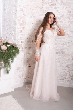 Gelin, beyaz tuğla bir duvarın arka planında tam gelişim içinde. Yüksek kalite fotoğraf