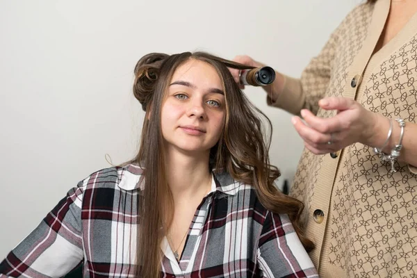 Stylisten Lockar Flickans Hår Med Locktång Högkvalitativt Foto — Stockfoto