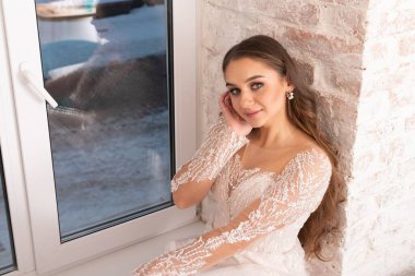 Pencere pervazında dalgalı saçları olan gelin. Yüksek kalite fotoğraf