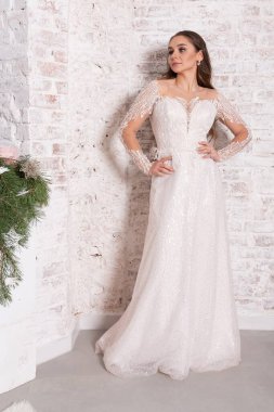 Tuğla duvara dayalı beyaz elbiseli gelin. Yüksek kalite fotoğraf