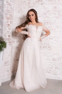 Tuğla duvara dayalı beyaz elbiseli gelin. Yüksek kalite fotoğraf