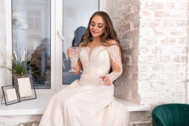 Pencere pervazında bir kadeh şarap olan gelin. Yüksek kalite fotoğraf