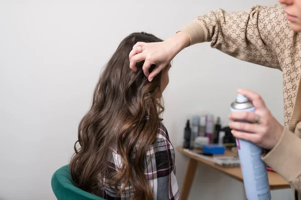 Stylista opravuje kadeře sprejem na vlasy — Stock fotografie