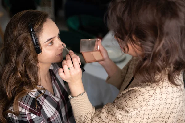 Maquiagem artista aplicando sombra para meninas pálpebra superior com um pincel — Fotografia de Stock