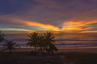 Denizin üzerinde günbatımında gökyüzünde renkli bulutlar renk değiştiriyor.