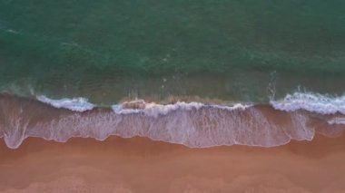 Hava üst görüntüsü dalga dalga sahile doğru sürüklendi. Sahildeki deniz kumu manzarası ve yaz günü dalga. Sahildeki deniz alanı. Mavi deniz, dalgalar Karon Sahili, Phuket Tayland 'a çarpıyor.. 