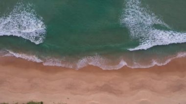 Hava üst görüntüsü dalga dalga sahile doğru sürüklendi. Sahildeki deniz kumu manzarası ve yaz günü dalga. Sahildeki deniz alanı. Mavi deniz, dalgalar Karon Sahili, Phuket Tayland 'a çarpıyor.. 