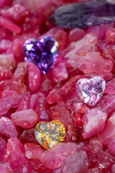 ルビーの原石の山の上のハート型のダイヤモンド — ストック写真