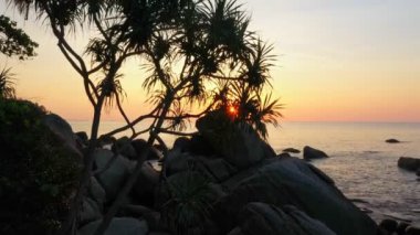 aerial view the sun going down to the horizon in sunset above the ocean.Nature video High quality footage Scene of Colorful romantic sky sunset with cloud in the sky background for creative nature and travel concept. 