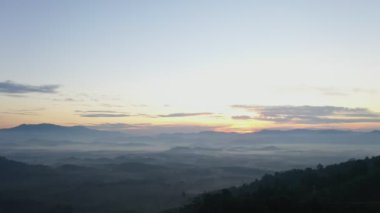 Hava manzaralı gün doğumu sisi vadiye doğru akıyor.