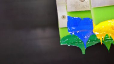 Yazıcı sapında renkli plastisol mürekkep çubuğu. .tee t-shirt fabrikası her zaman plastisol mürekkep kullanır. Tişörte baskı yapmak için. Her kumaş için. Stüdyo. Damlayan renkli boya.