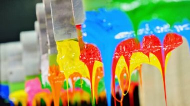 Yazıcı sapında renkli plastisol mürekkep çubuğu. .tee t-shirt fabrikası her zaman plastisol mürekkep kullanır. Tişörte baskı yapmak için. Her kumaş için. Stüdyo. Damlayan renkli boya.