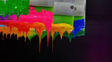 Yazıcı sapında renkli plastisol mürekkep çubuğu. .tee t-shirt fabrikası her zaman plastisol mürekkep kullanır. Tişörte baskı yapmak için. Her kumaş için. Stüdyo. Damlayan renkli boya.