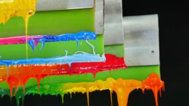 Yazıcı sapında renkli plastisol mürekkep çubuğu. .tee t-shirt fabrikası her zaman plastisol mürekkep kullanır. Tişörte baskı yapmak için. Her kumaş için. Stüdyo. Damlayan renkli boya.