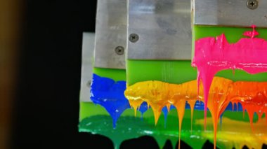 Yazıcı sapında renkli plastisol mürekkep çubuğu. .tee t-shirt fabrikası her zaman plastisol mürekkep kullanır. Tişörte baskı yapmak için. Her kumaş için. Stüdyo. Damlayan renkli boya.