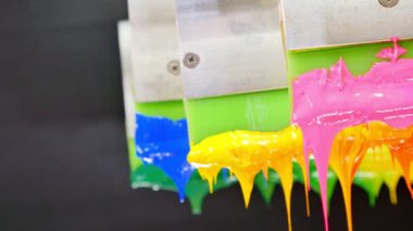 Yazıcı sapında renkli plastisol mürekkep çubuğu. .tee t-shirt fabrikası her zaman plastisol mürekkep kullanır. Tişörte baskı yapmak için. Her kumaş için. Stüdyo. Damlayan renkli boya.