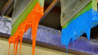 Yazıcı sapında renkli plastisol mürekkep çubuğu. .tee t-shirt fabrikası her zaman plastisol mürekkep kullanır. Tişörte baskı yapmak için. Her kumaş için. Stüdyo. Damlayan renkli boya.