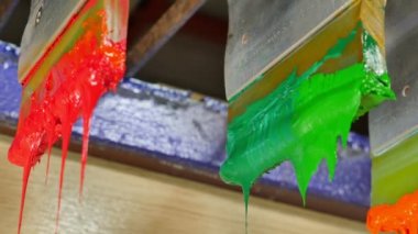 Yazıcı sapında renkli plastisol mürekkep çubuğu. .tee t-shirt fabrikası her zaman plastisol mürekkep kullanır. Tişörte baskı yapmak için. Her kumaş için. Stüdyo. Damlayan renkli boya.