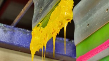 Yazıcı sapında renkli plastisol mürekkep çubuğu. .tee t-shirt fabrikası her zaman plastisol mürekkep kullanır. Tişörte baskı yapmak için. Her kumaş için. Stüdyo. Damlayan renkli boya.