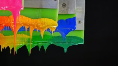 Yazıcı sapında renkli plastisol mürekkep çubuğu. .tee t-shirt fabrikası her zaman plastisol mürekkep kullanır. Tişörte baskı yapmak için. Her kumaş için. Stüdyo. Damlayan renkli boya.