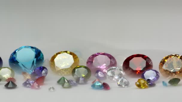 Kleurrijke Diamanten Van Verschillende Afmetingen Een Witte Achtergrond — Stockvideo