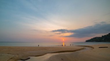 Plajın üstündeki zaman atlamalı bulutlu hava. Karon sahilindeki küçük bir kanaldan denize akan tatlı su Phuket Tayland 'da. Beyaz kum ve yumuşak dalgalar rahatlamak ve yüzmek için mükemmel..