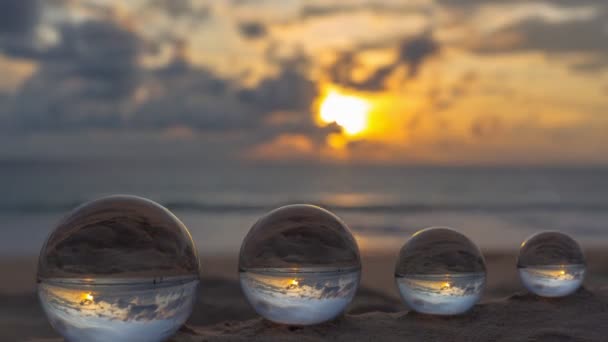 ビーチに置かれた4つのクリスタルボールの中の日没の時間経過ビュー 海によるクリスタルボールの美しい自然 ユニークで創造的な旅行と自然のアイデアビデオ4Kクリップ — ストック動画