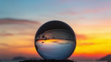 view of colorful nature at sunset inside crystal ball..beautiful sunset over sea in a crystal ball on the beach video 4K. .Nature video High quality footage in nature and travel concept.
