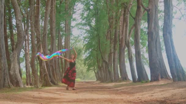 드레스를 여자는 스카프를 바람에 Fluttering 보이고 배경이있는 나무의 — 비디오