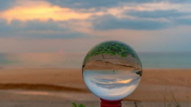 timelapse sunset in crystal ball the image that appears in an upside-down looks strange.The natural view of the sea and sky in beautiful sunset are unconventional and beautiful inside crystal ball