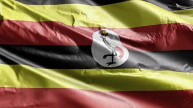 Rüzgarda sallanan Uganda tekstil bayrağı. Uganda bayrağı rüzgarda sallanıyor. Kumaş dokular. Tam dolgu arkaplanı. 10 saniye döngü. 