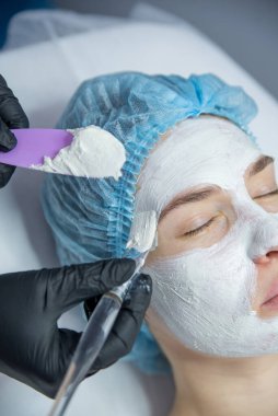 Kozmetik bilimci resepsiyonundaki bir kadın güzel bir yüz derisi için bir prosedür uyguluyor.