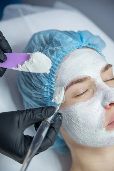 Kozmetik bilimci resepsiyonundaki bir kadın güzel bir yüz derisi için bir prosedür uyguluyor.