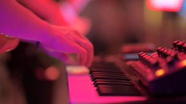 Bir gece kulübünde bir müzisyen bir sentezleyici çalıyor.