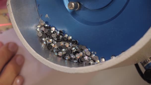 Het proces van het aanbrengen van strass steentjes op kleding met behulp van een industriële machine. — Stockvideo