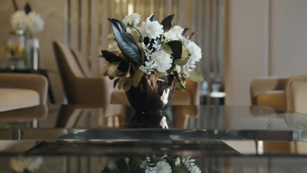 Η υπηρέτρια βάζει ένα βάζο με φρέσκα λουλούδια στο τραπέζι.. Royalty Free Πλάνα Αρχείου