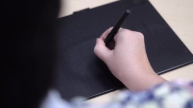 Bir tasarımcı elektronik tablet üzerine resim çizer. Yüksek kaliteli FullHD görüntüler