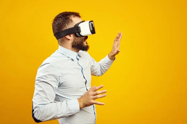 Side view of young man wearing virtual reality helmet, touching the air — Stock Photo, Image