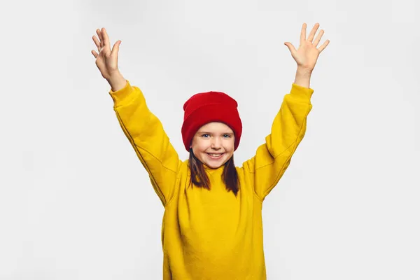 하얀 배경에서 승리의 표시로 손을 들고 웃는 귀여운 소녀 — 스톡 사진