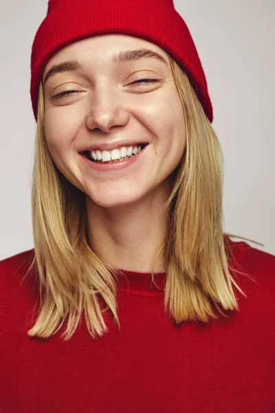 멋진 붉은 모자와 근육질의 옷을 입고 눈을 감은 채 미소짓고 있는 흥 행객 여자 — 스톡 사진