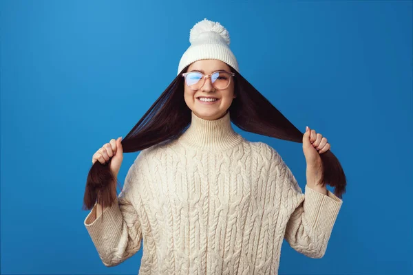 Chica sosteniendo el pelo, chica feliz y divertida, aislado sobre fondo azul — Foto de Stock