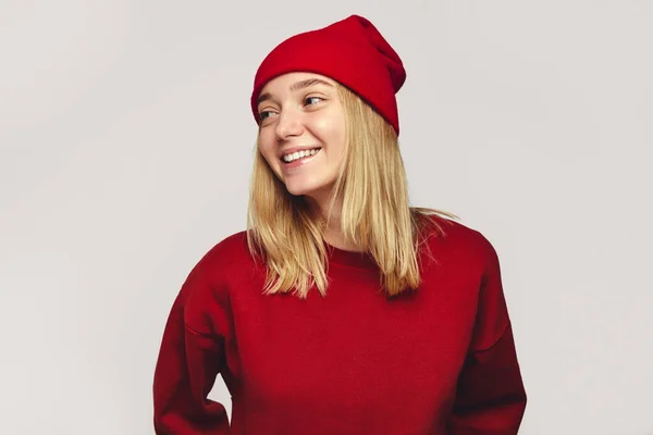 Mulher hipster elegante vestindo chapéu vermelho elegante e camisola, sorrindo para a câmera — Fotografia de Stock