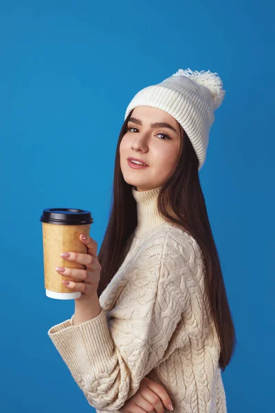 Girl wearing white hat and sweater, enjoys drinking coffee from takeout cup — Stock Photo, Image