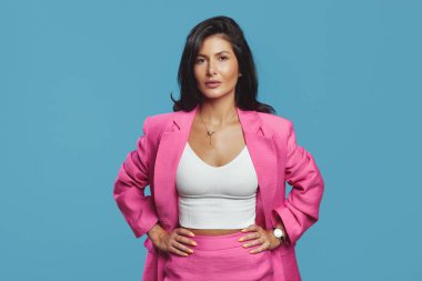Pembe takım elbiseli ciddi bir iş kadını el ele tutuşuyor.