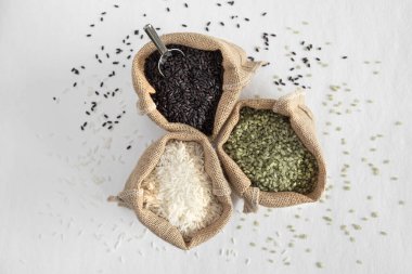 Üç çeşit pirinç, yeşil, beyaz ve siyah, keseli çantalarda.